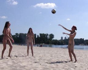 Three sexy nudist girls play naked volleyball together at the beach