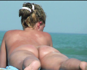 Beautiful nudist blonde enjoys a hot summer day sunbathing