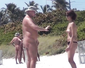 Delectable MILF enjoys being surrounded by older naked men in a nudist park